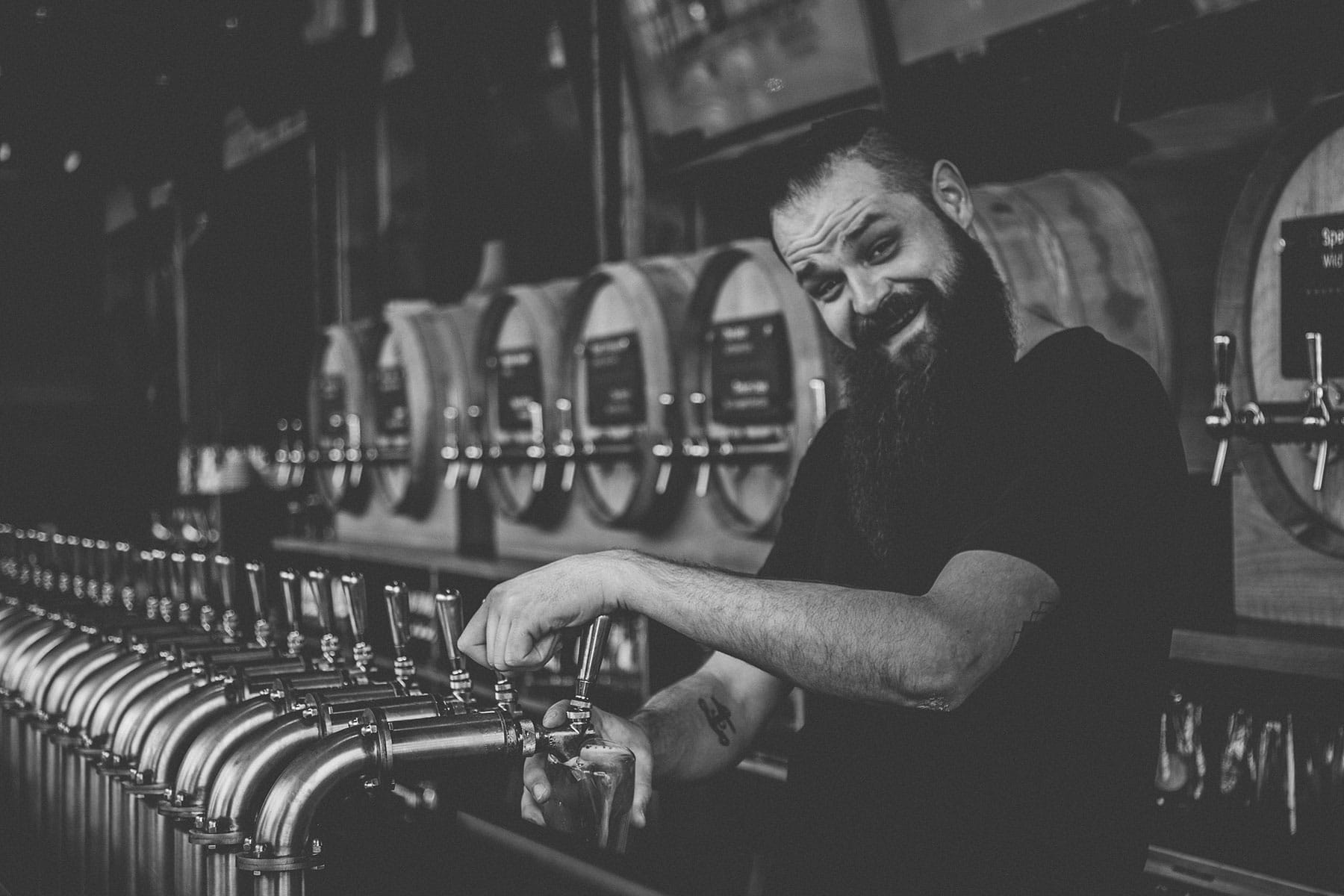 A bartender pouring beer from taps